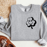 a sweater with a clover on it next to a pair of shoes