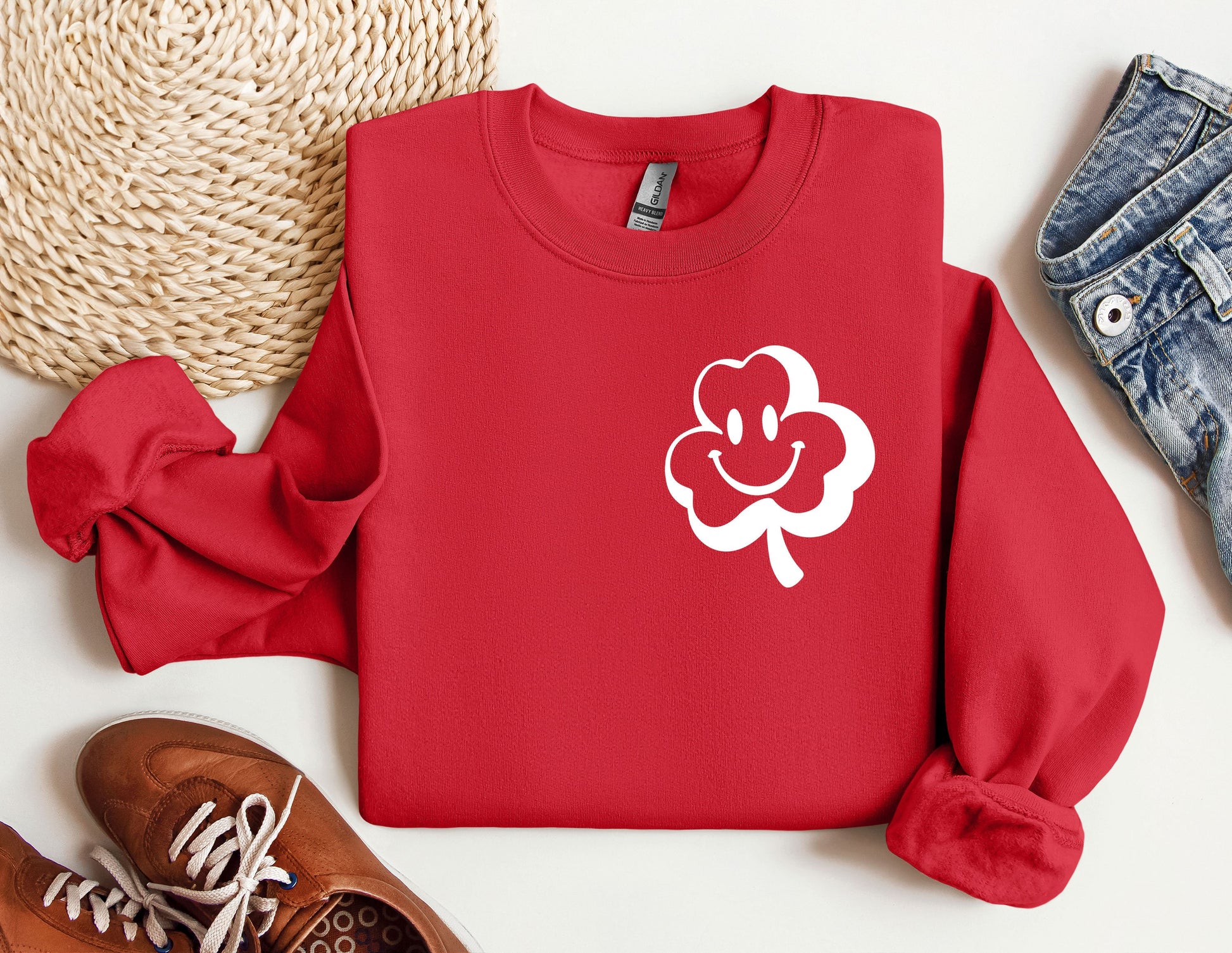 a red sweater with a white clover on it