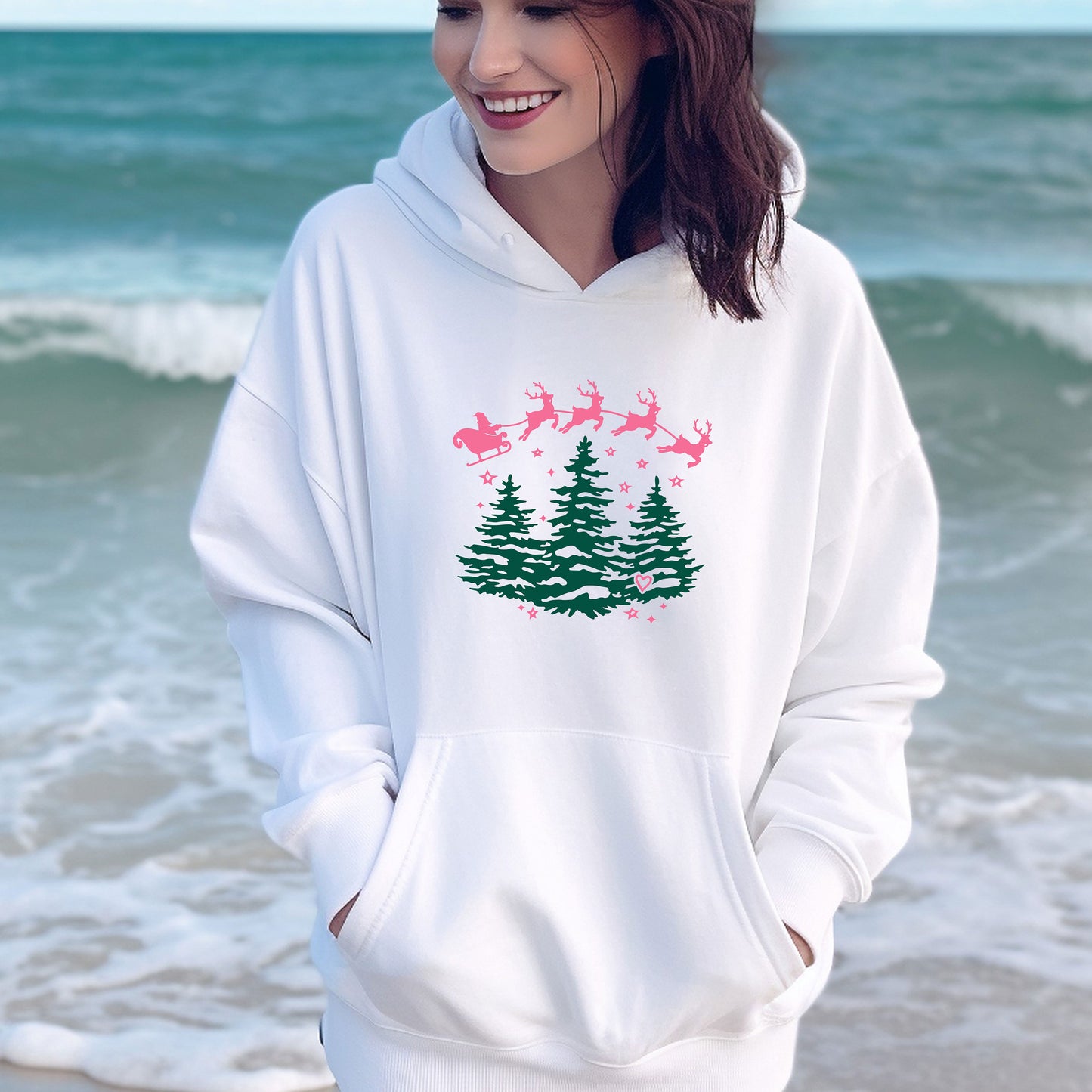 a woman standing on the beach wearing a christmas sweatshirt