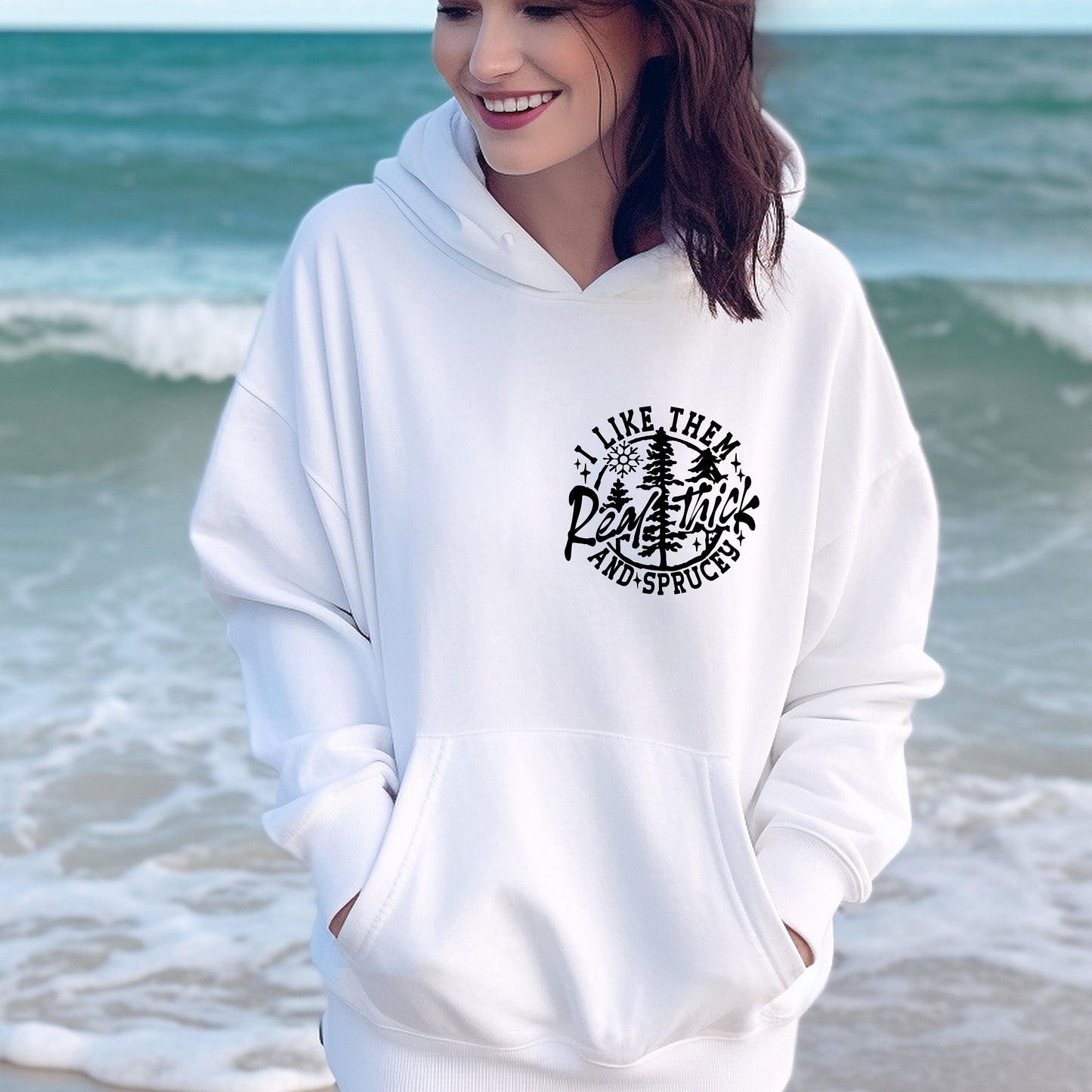 a woman standing on the beach wearing a white hoodie