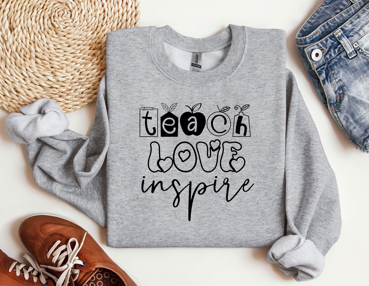 a sweatshirt with the words teach love inspire on it