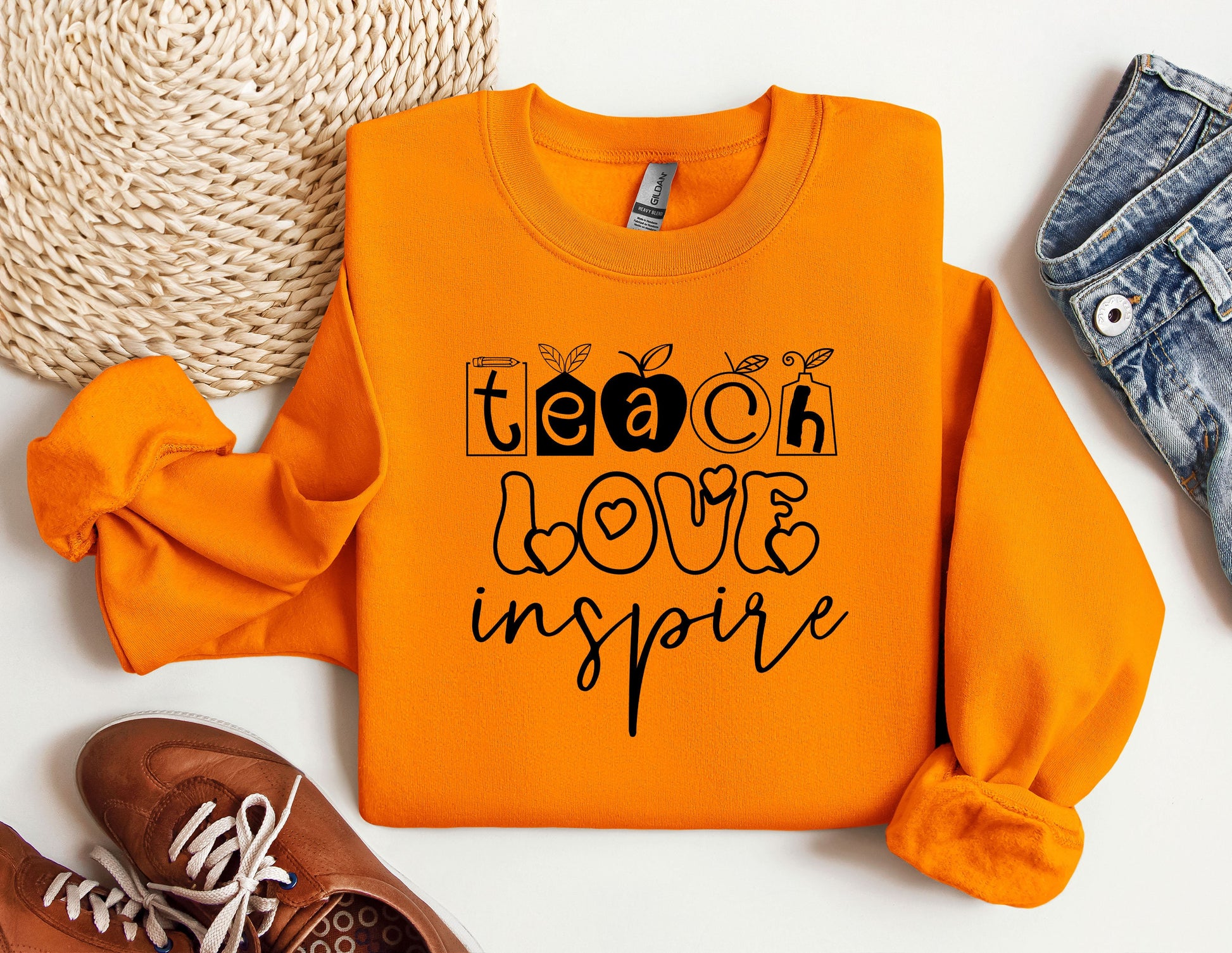 an orange sweatshirt with the words teach love inspire on it