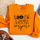 an orange sweatshirt with the words teach love inspire on it
