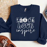 a blue sweatshirt with the words teach love inspire on it