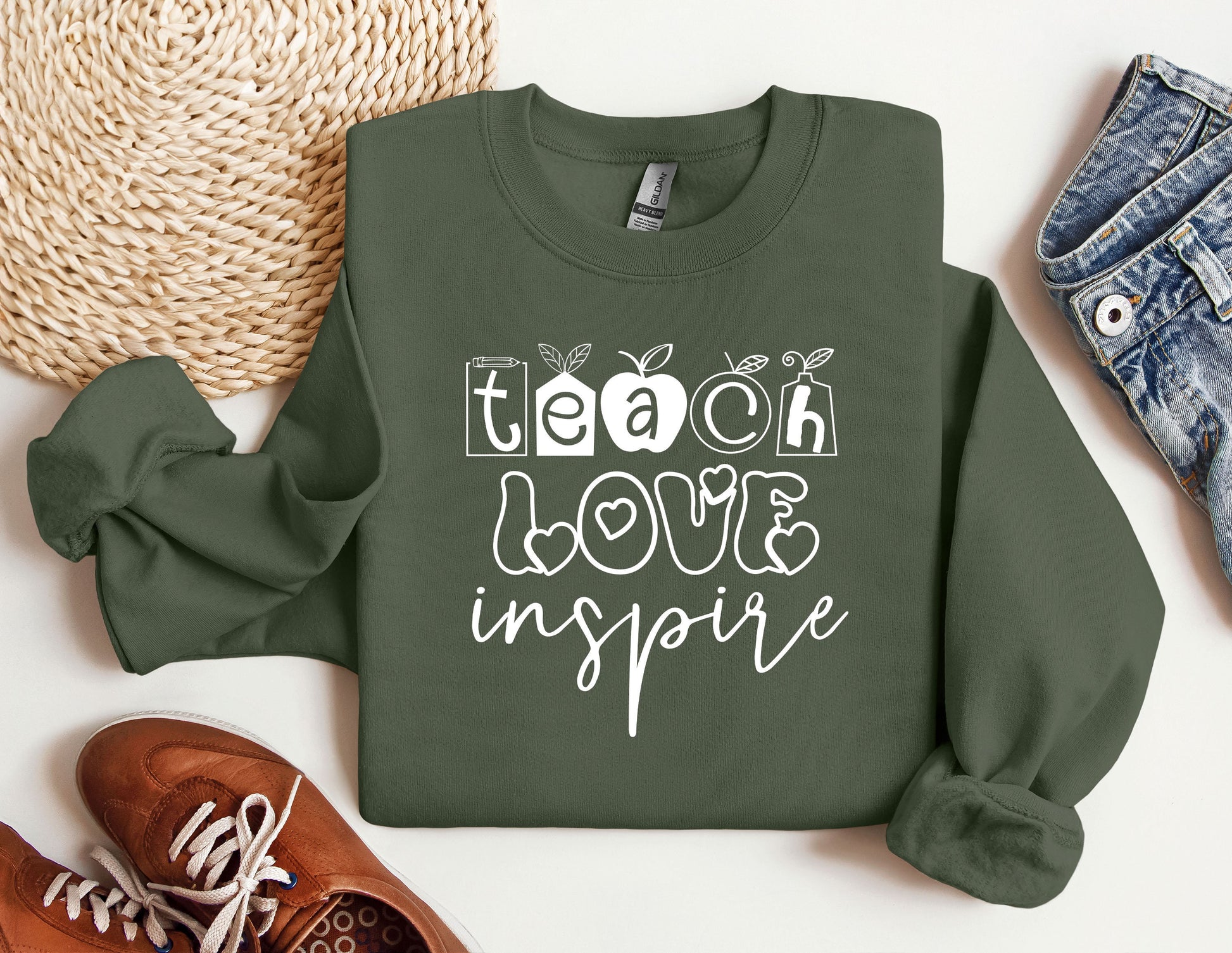 a green sweatshirt with the words teach love inspire on it