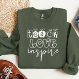 a green sweatshirt with the words teach love inspire on it