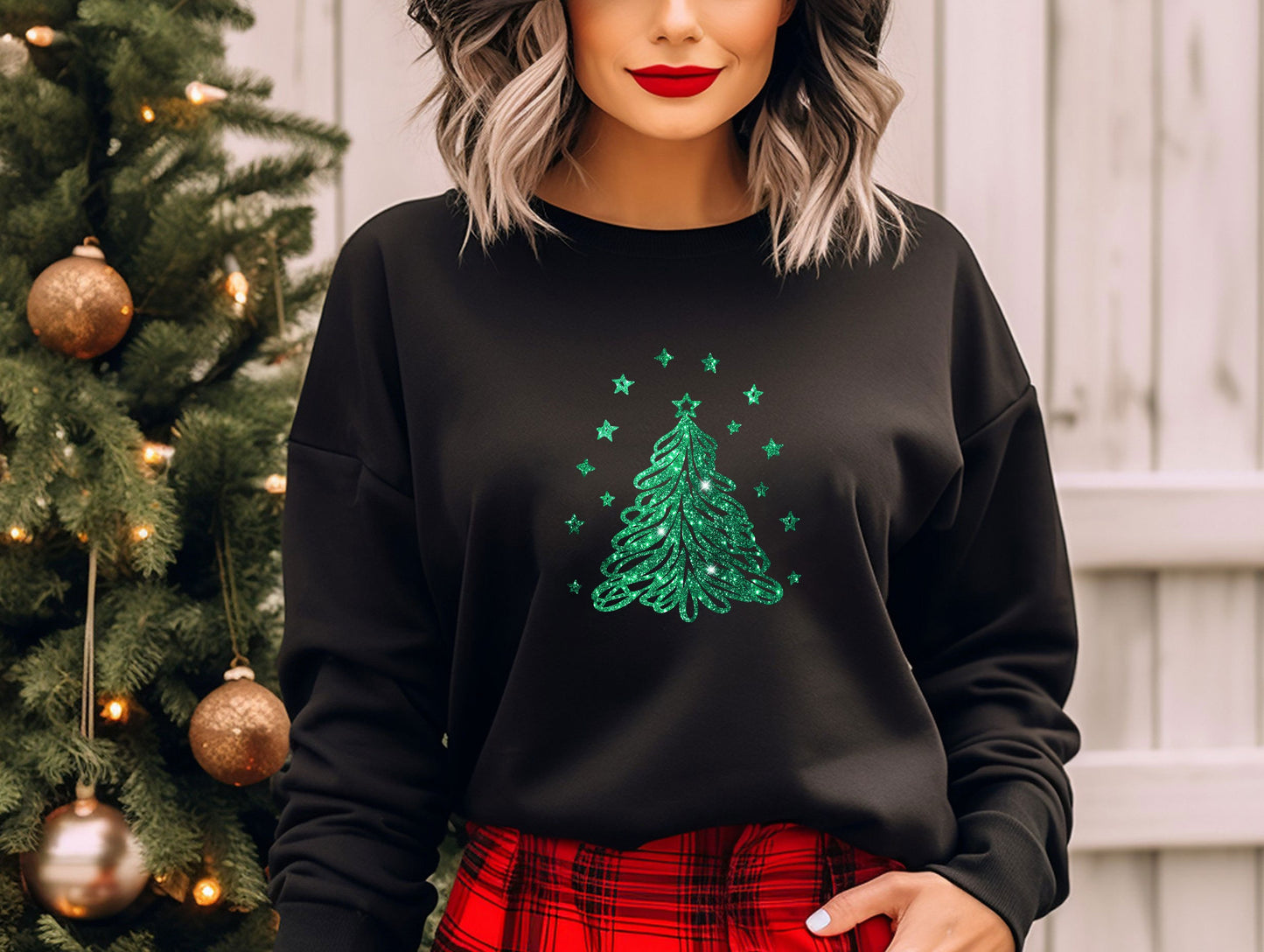 a woman wearing a black sweatshirt with a green christmas tree on it