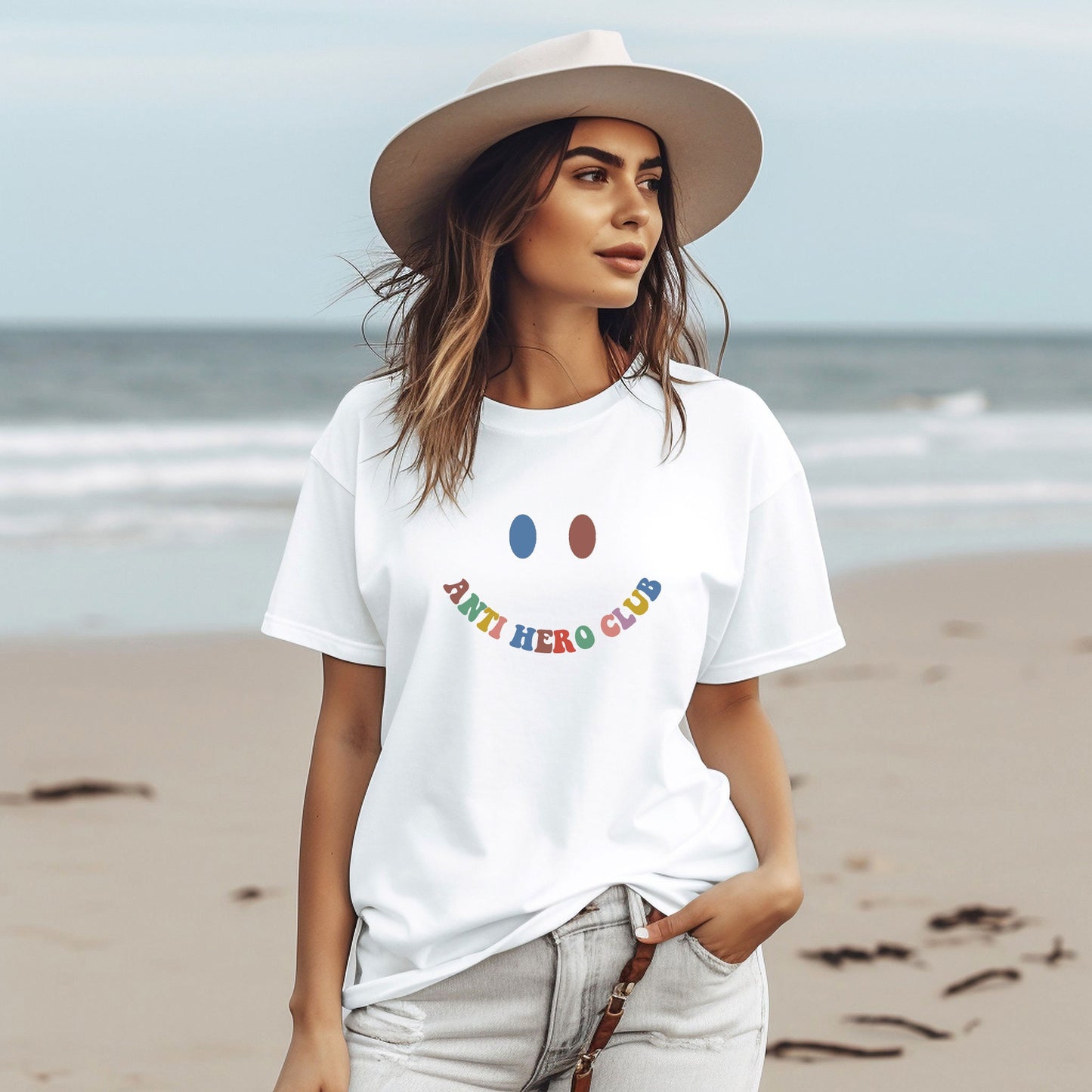 a woman wearing a white t - shirt and hat standing on a beach