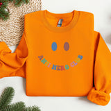 an orange sweatshirt with a smiley face on it