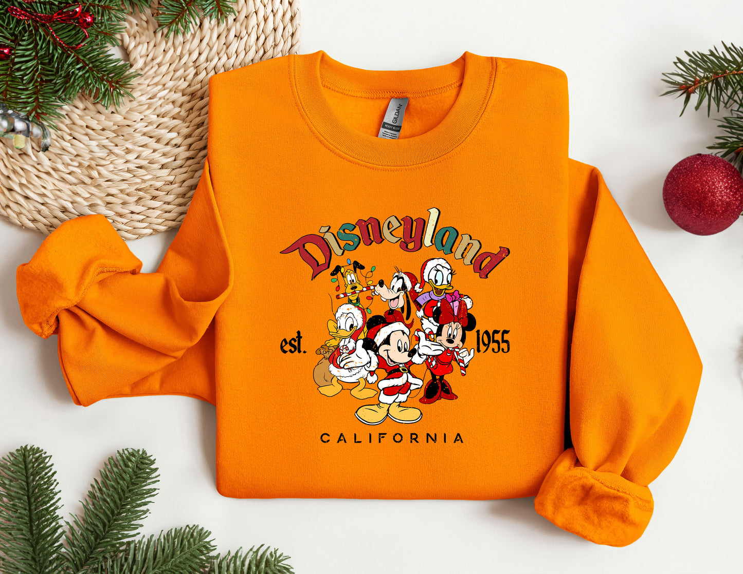 an orange sweatshirt with a picture of mickey and friends on it