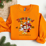 an orange sweatshirt with a picture of mickey and friends on it