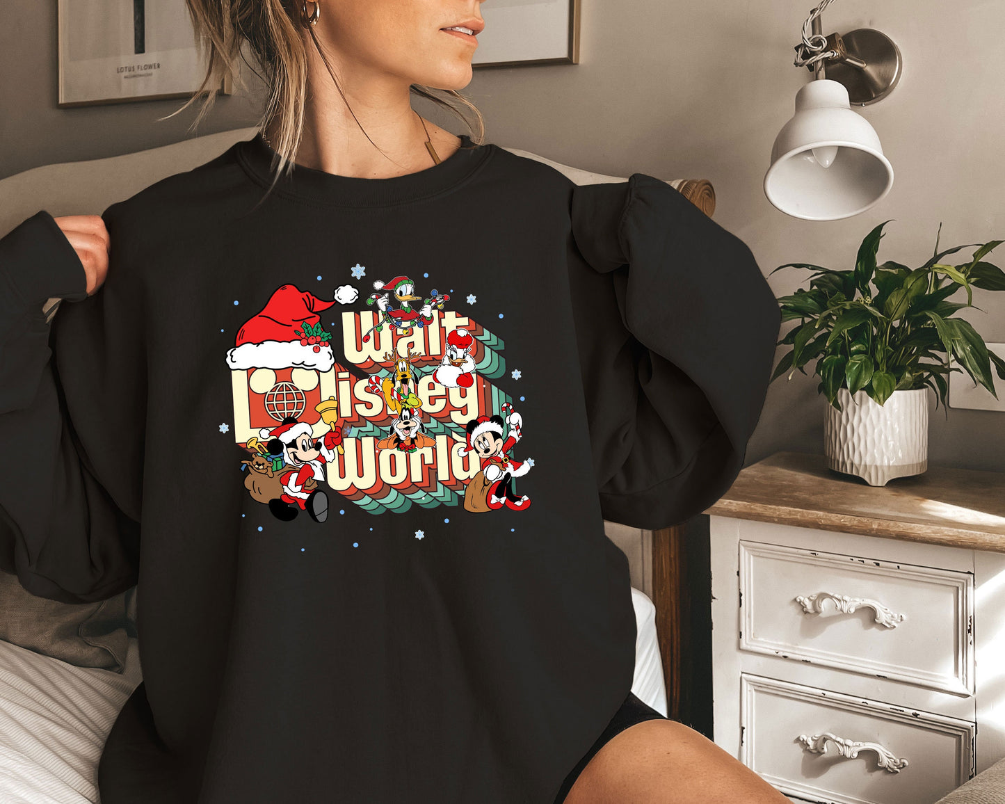 a woman wearing a black sweatshirt with a christmas message on it