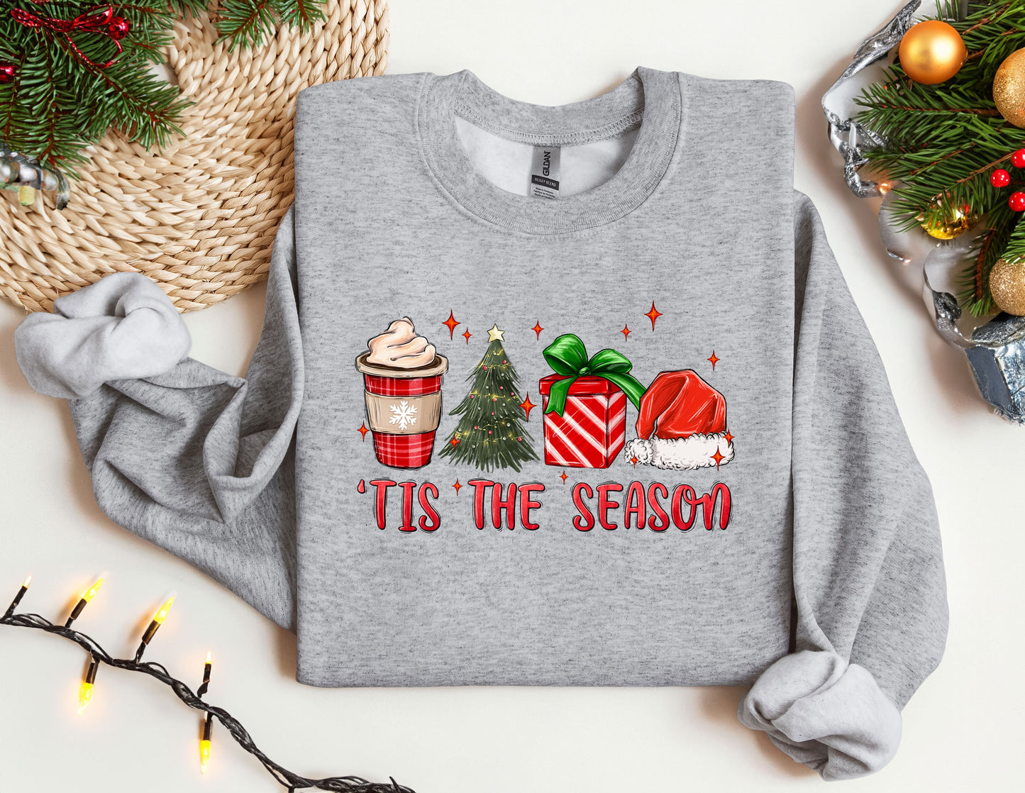 a gray sweater with a christmas tree and presents on it