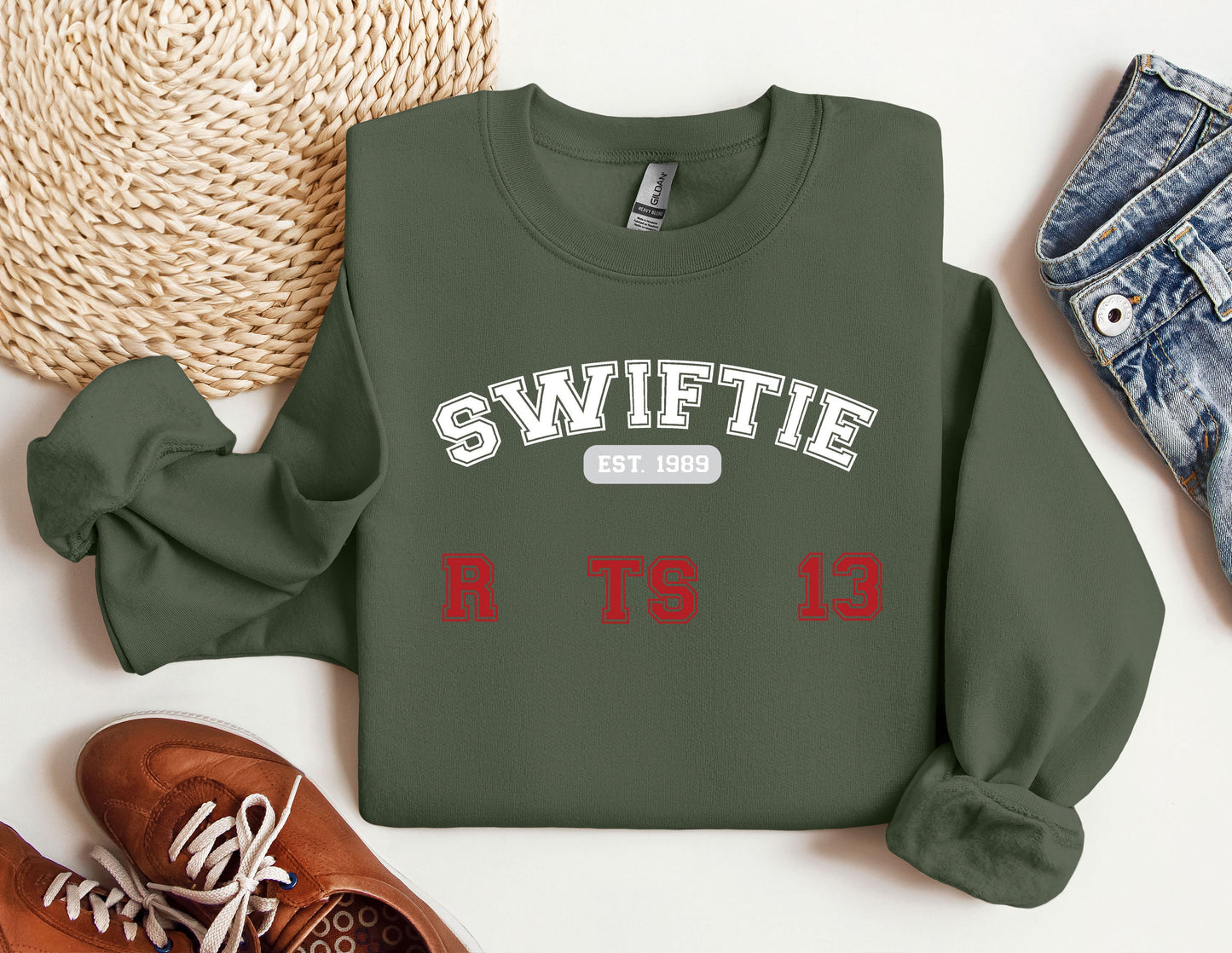 a sweater with the words swiffie on it next to a pair of shoes