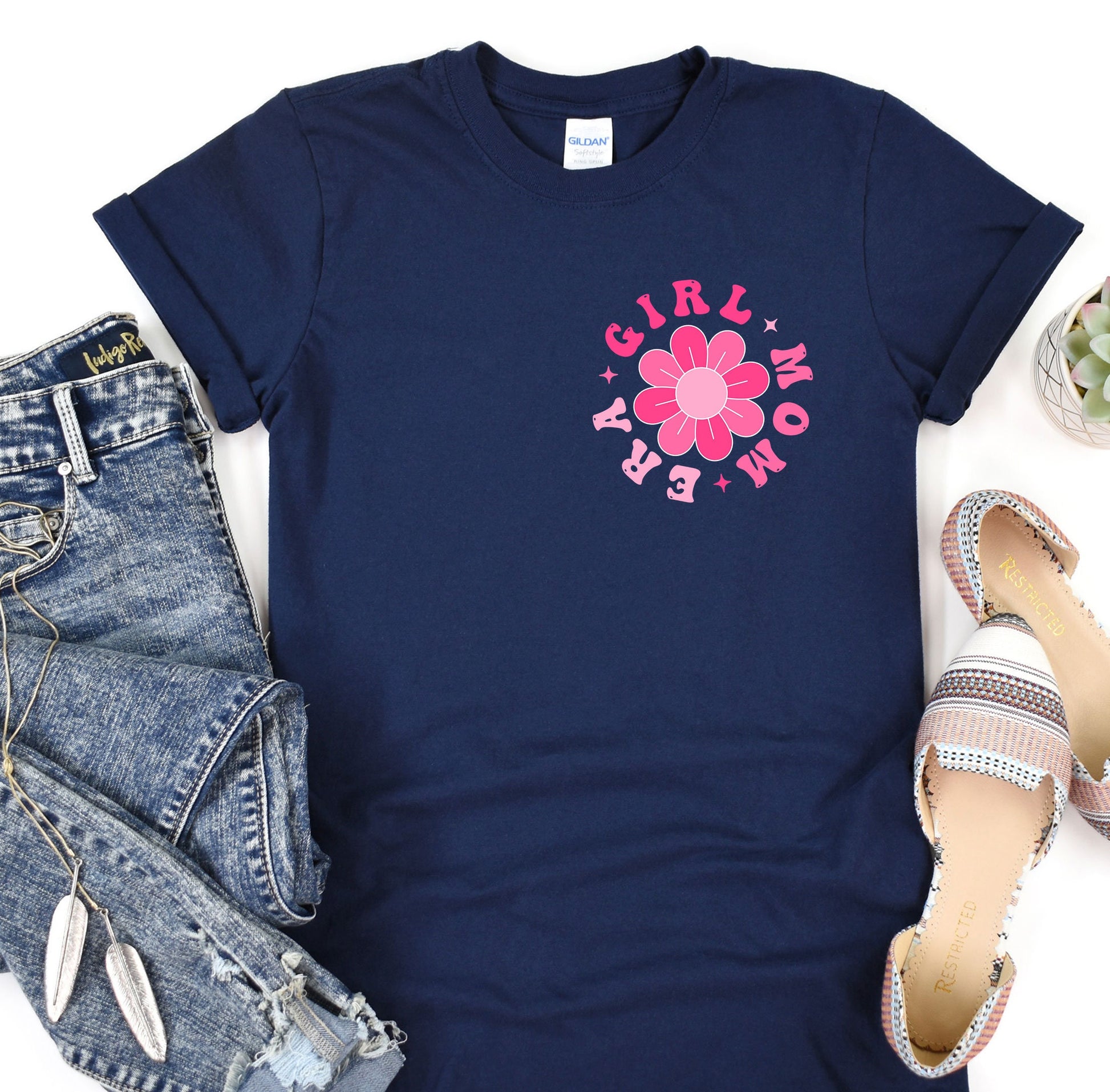 a t - shirt with a flower on it next to a pair of jeans