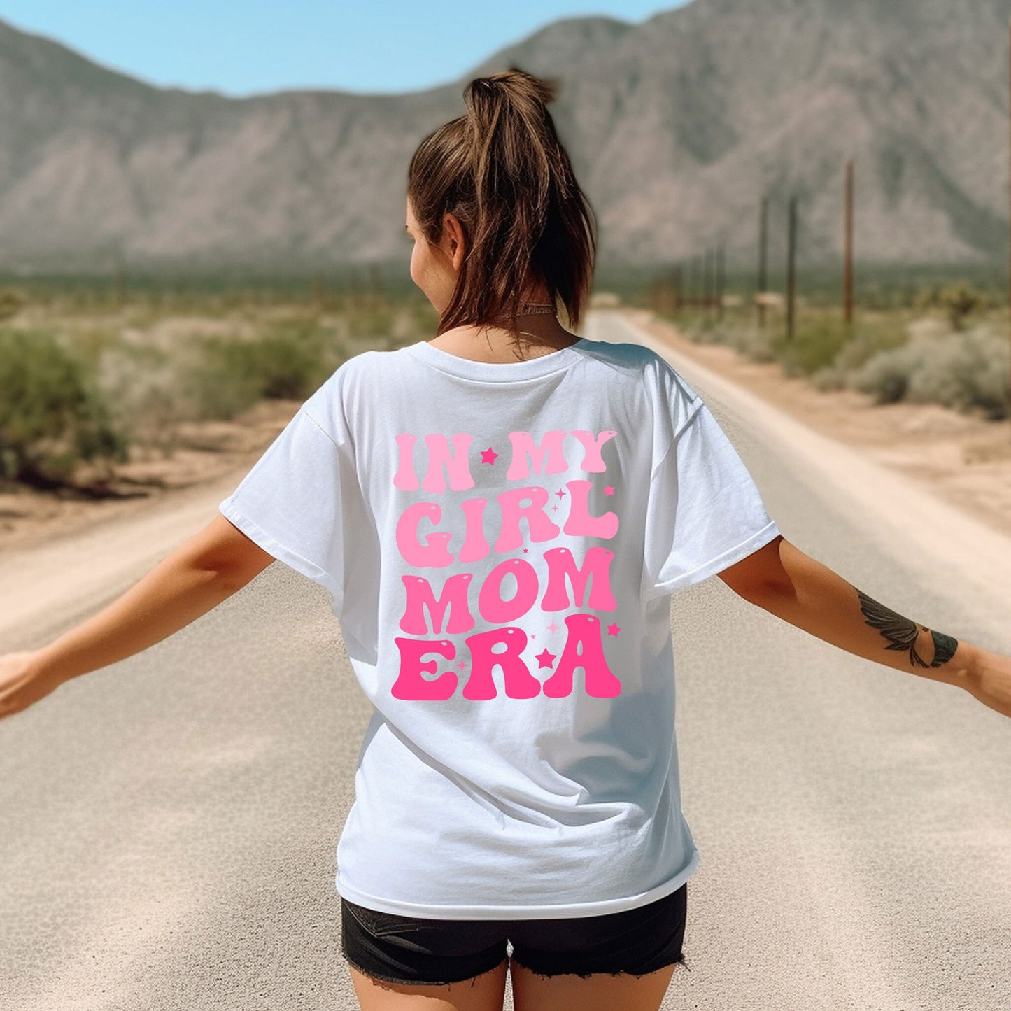 a woman walking down a road with her arms outstretched