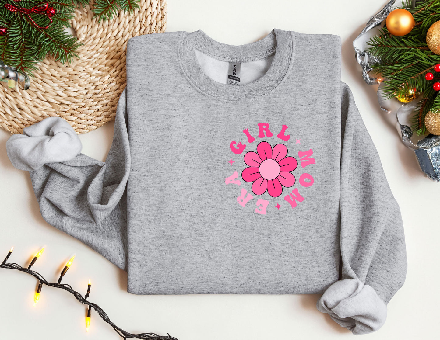 a gray sweater with a pink flower on it