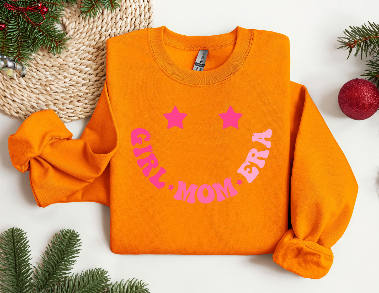 an orange sweatshirt with a pink mom on it