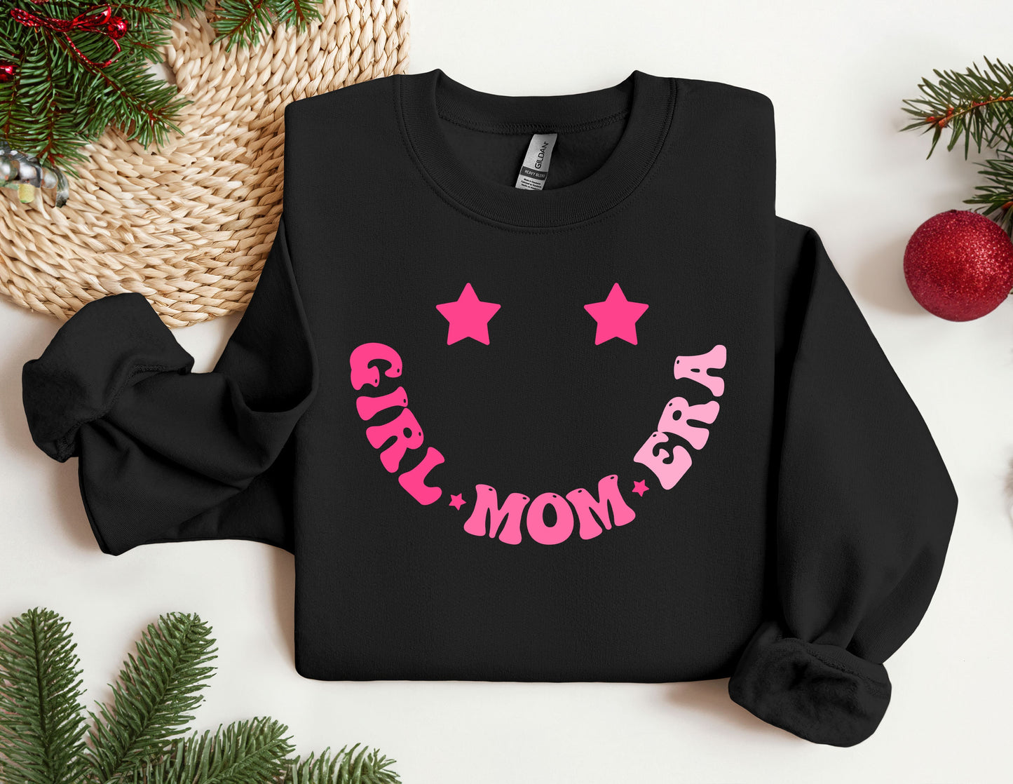 a black sweatshirt with pink stars and a smiley face