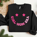 a black sweatshirt with pink stars and a smiley face