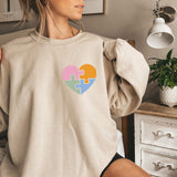 a woman sitting on a bed holding onto a sweater