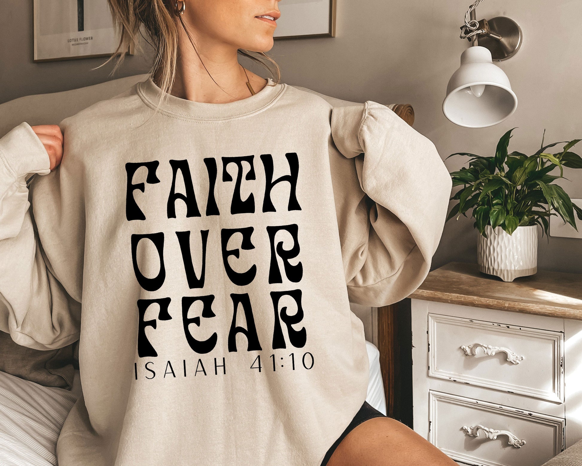 a woman wearing a sweatshirt that says faith over fear