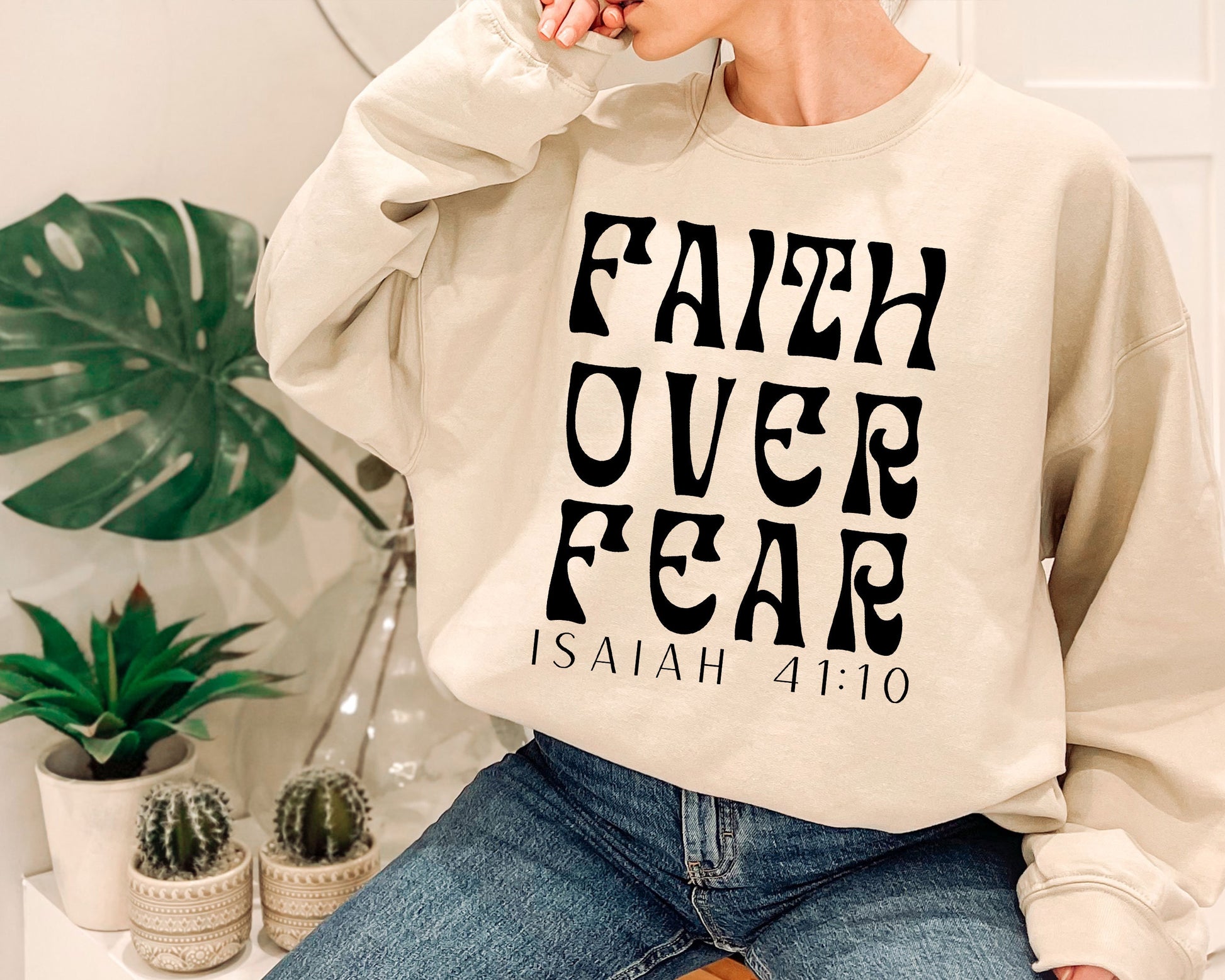 a woman wearing a sweatshirt that says faith over fear