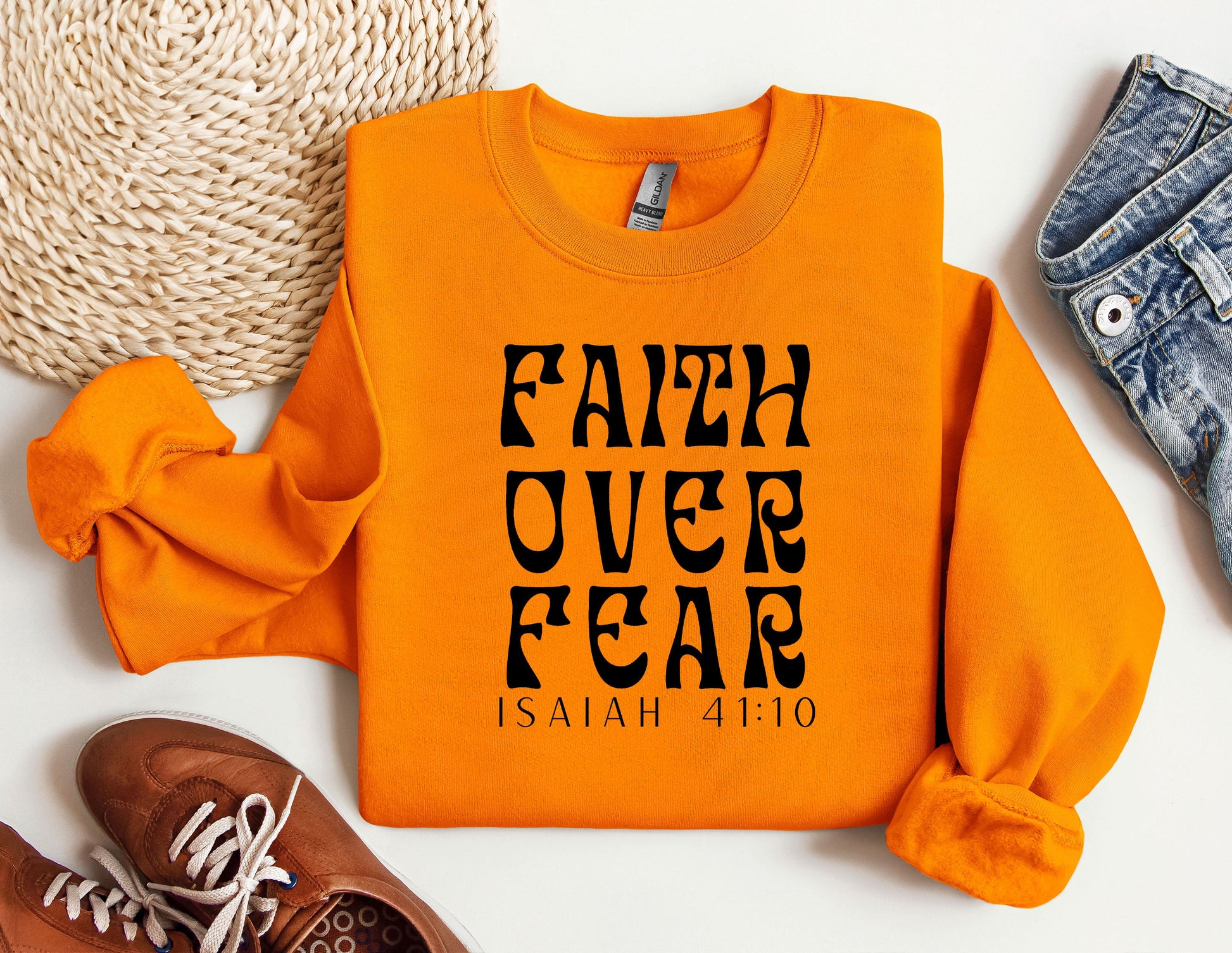 an orange sweatshirt with the words faith over fear printed on it