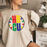 a woman sitting on a bed wearing a sweatshirt