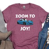 a t - shirt that says zoom to joy next to a pair of jeans