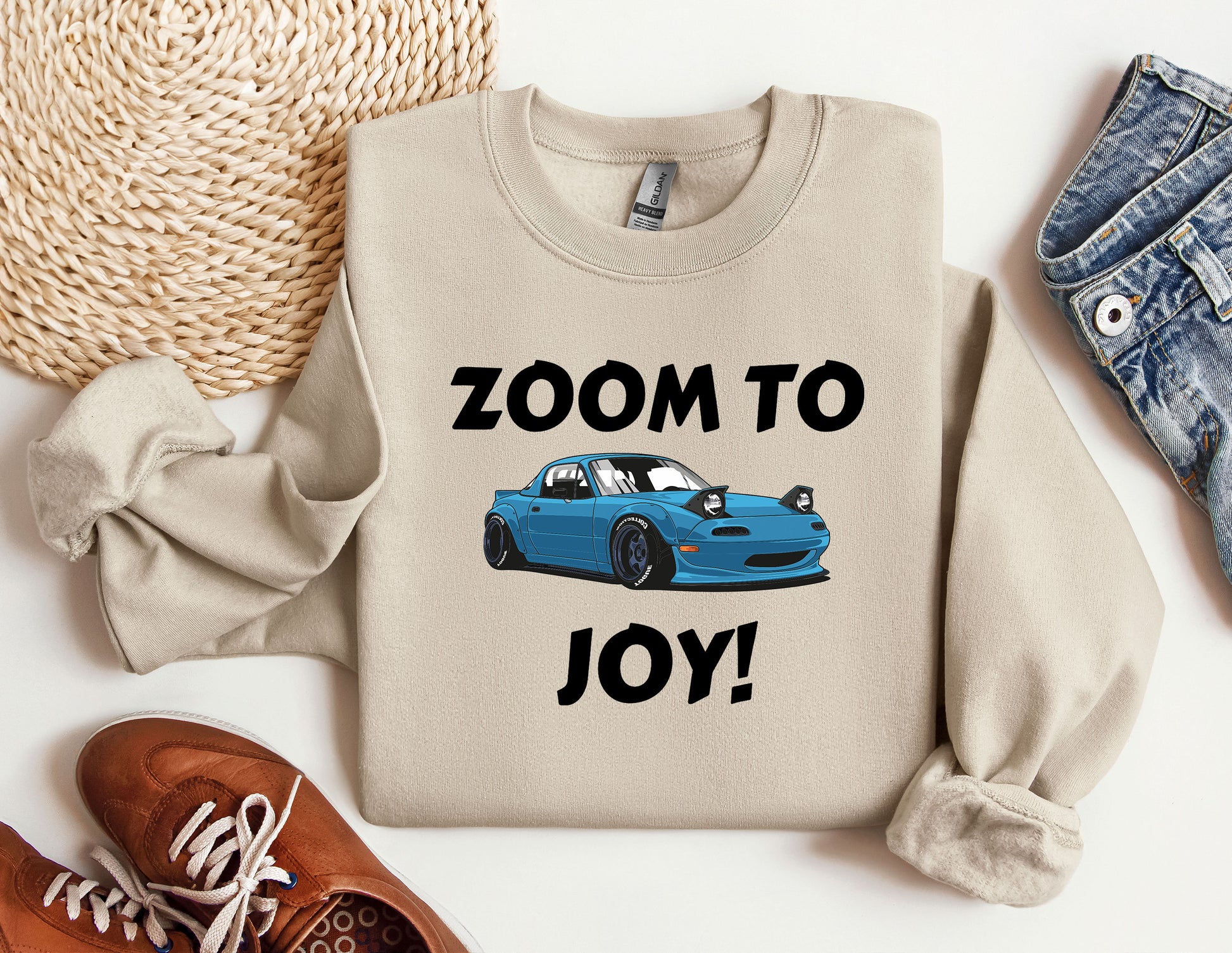 a sweater that says zoom to joy with a blue car on it