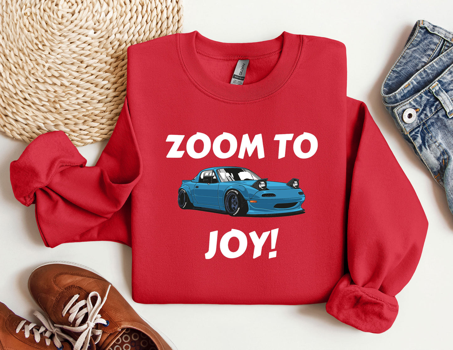 a red shirt with a blue car on it that says zoom to joy