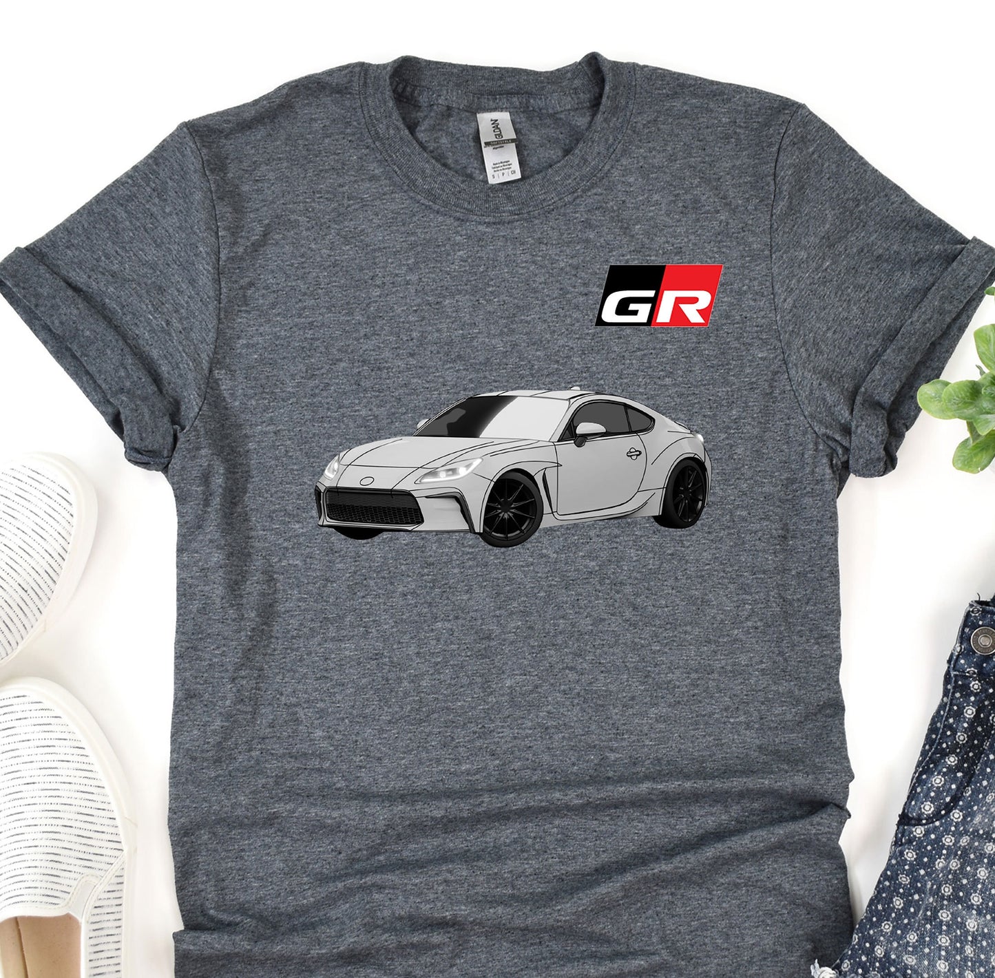 a gray t - shirt with a picture of a car on it