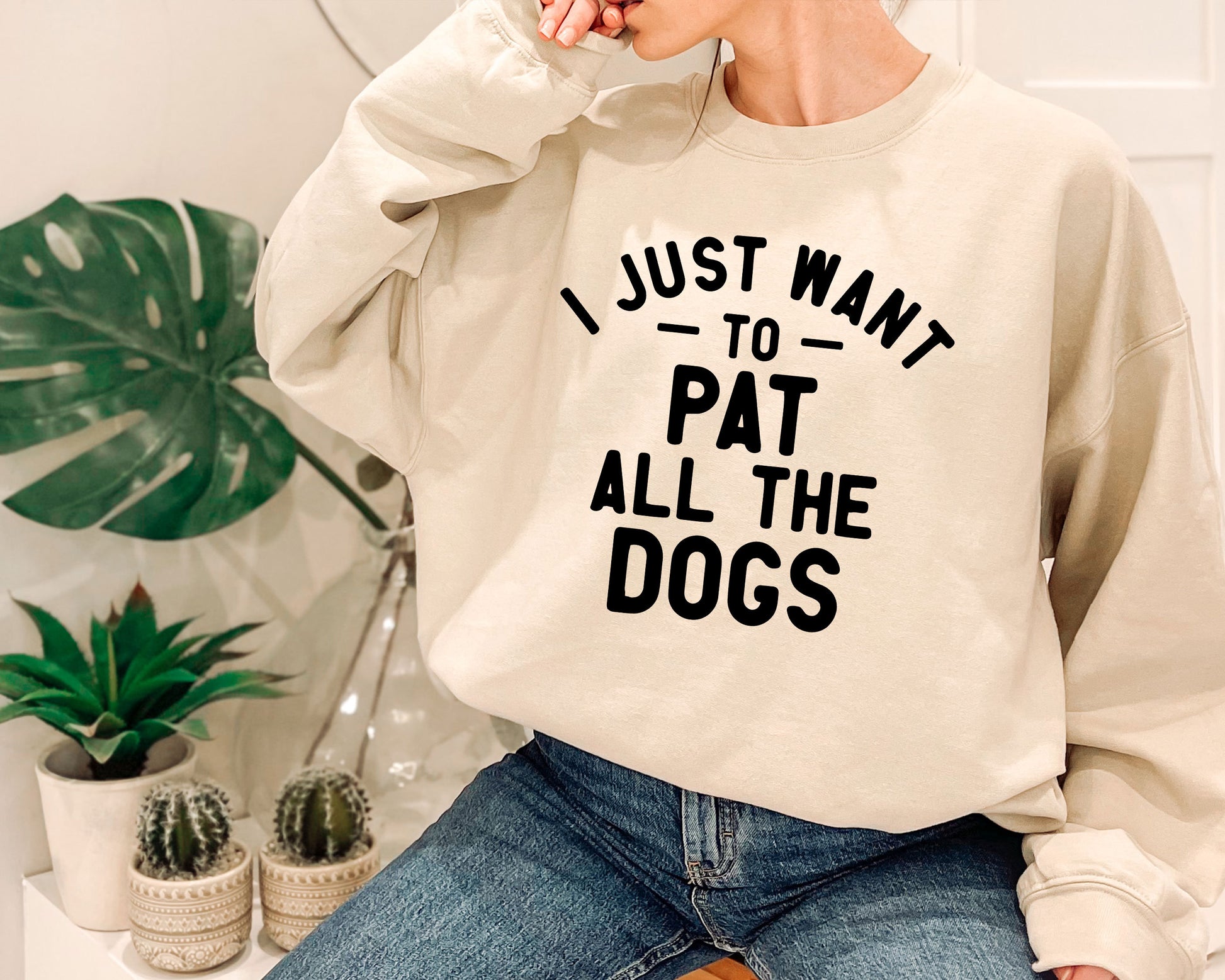 a woman wearing a sweatshirt that says i just want to pat all the dogs