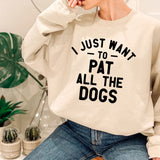 a woman wearing a sweatshirt that says i just want to pat all the dogs