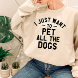 a woman wearing a sweatshirt that says i just want to pet all the dogs