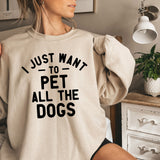 a woman wearing a sweatshirt that says i just want to pet all the dogs
