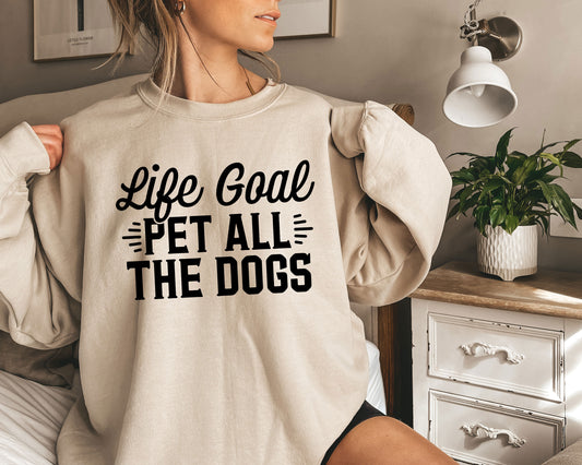 a woman wearing a sweatshirt that says life goal pet all the dogs