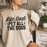 a woman wearing a sweatshirt that says life goal pet all the dogs