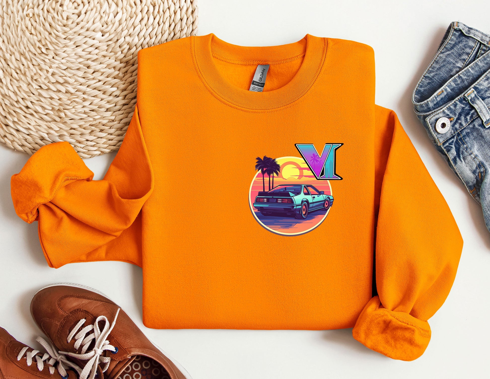 an orange sweatshirt with a vw logo on it next to a pair of shoes