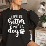 a woman sitting on a bed wearing a black sweatshirt that says life is better with