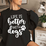a woman sitting on a bed wearing a black sweatshirt that says life is better with