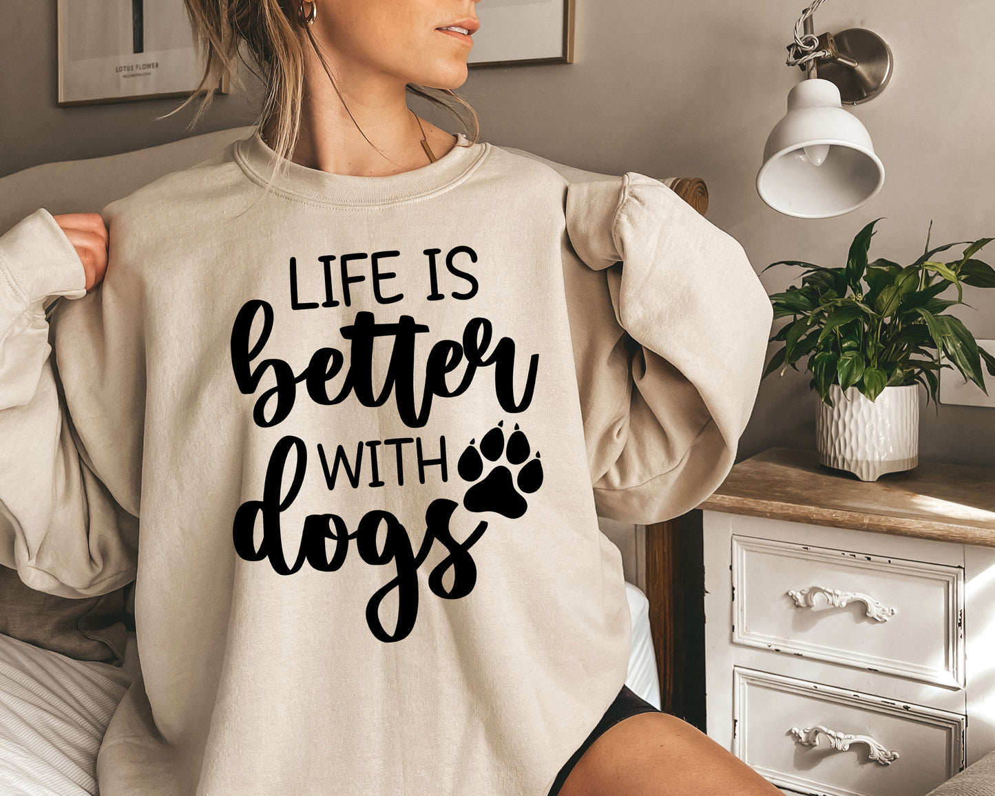 a woman wearing a sweatshirt that says life is better with dogs