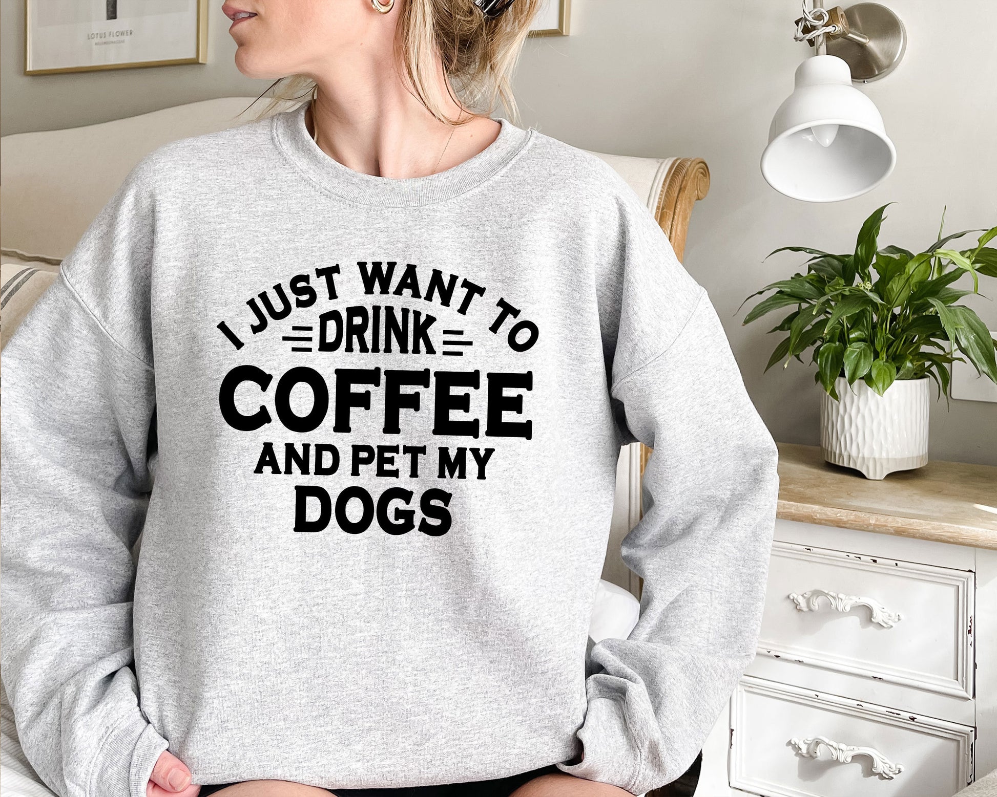 a woman wearing a sweatshirt that says i just want to drink coffee and pet my