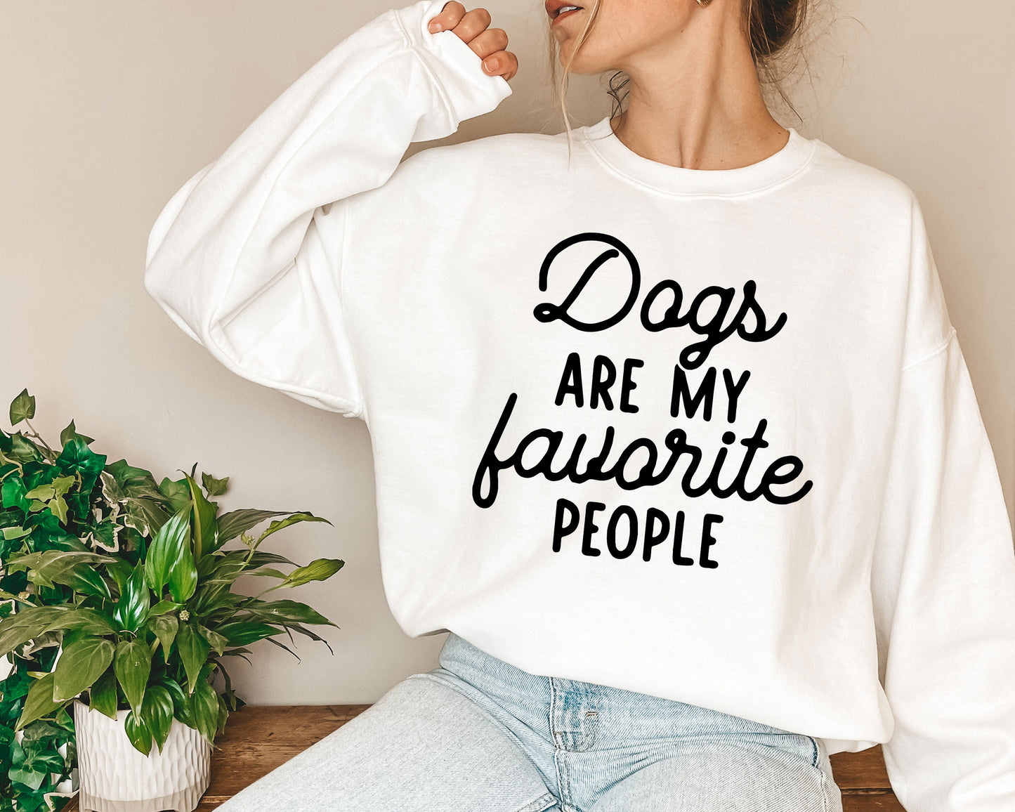 a woman wearing a sweatshirt that says dogs are my favorite people