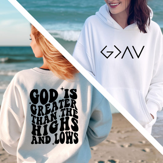 two women standing on a beach wearing sweatshirts that say god is greater than his