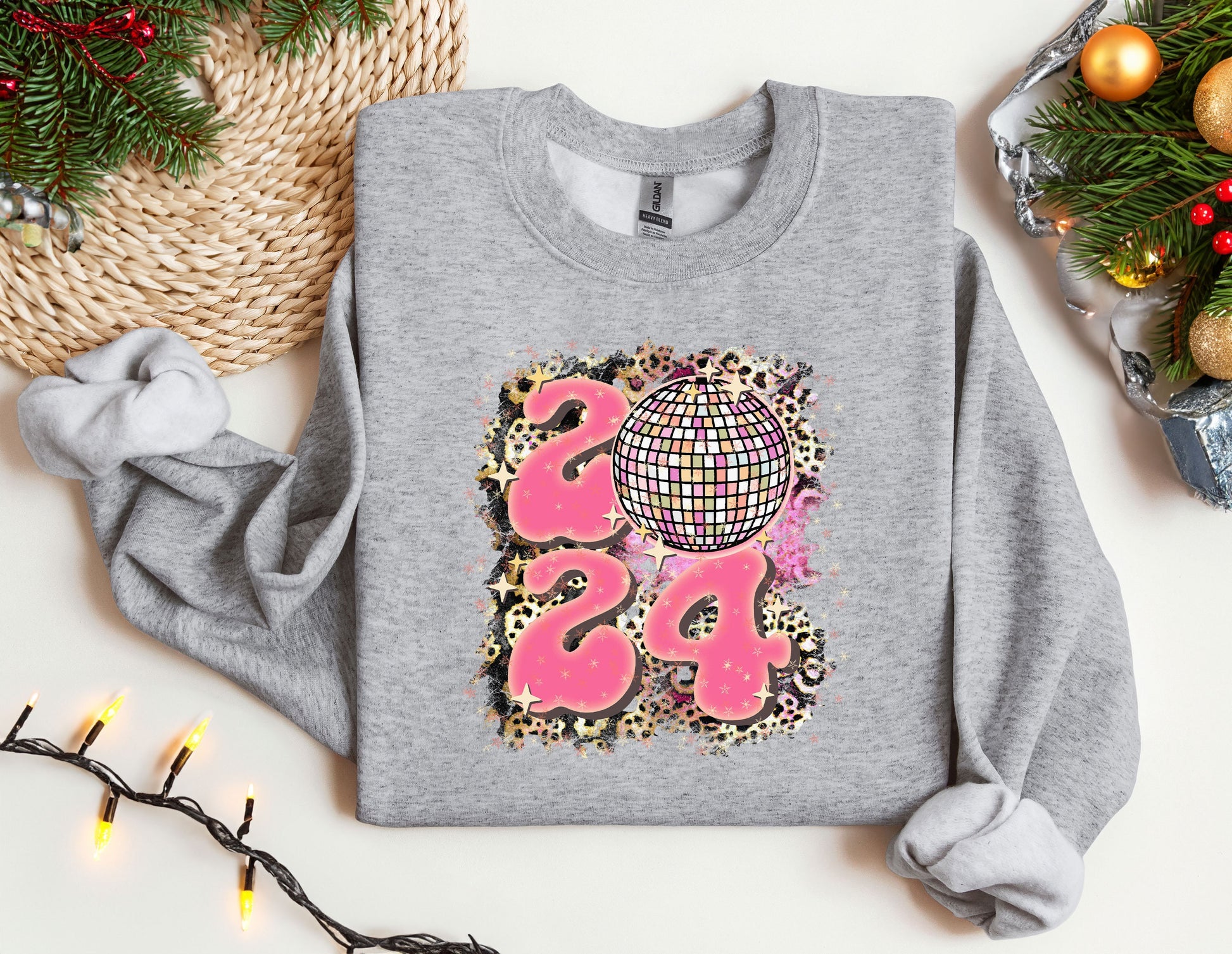 a sweater with a disco ball on it next to a christmas tree