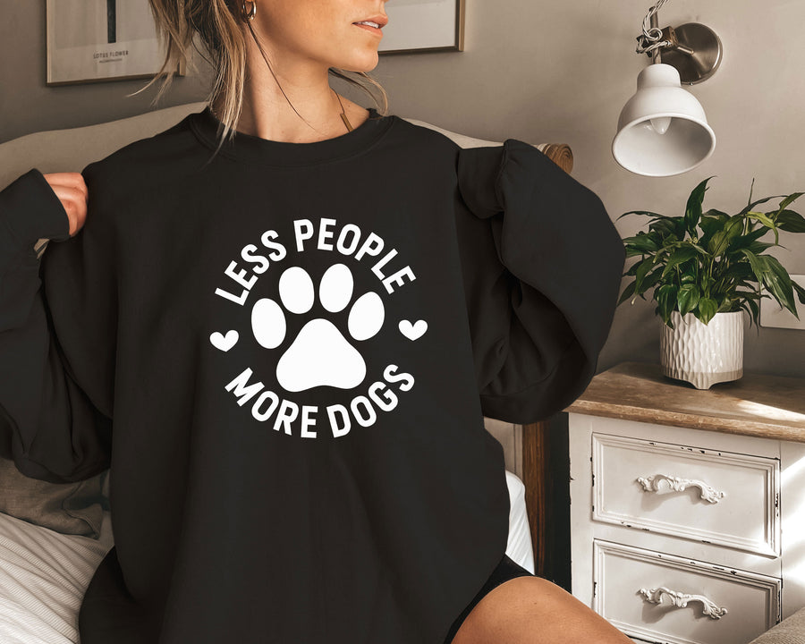 a woman sitting on a bed wearing a black shirt with a dog's paw