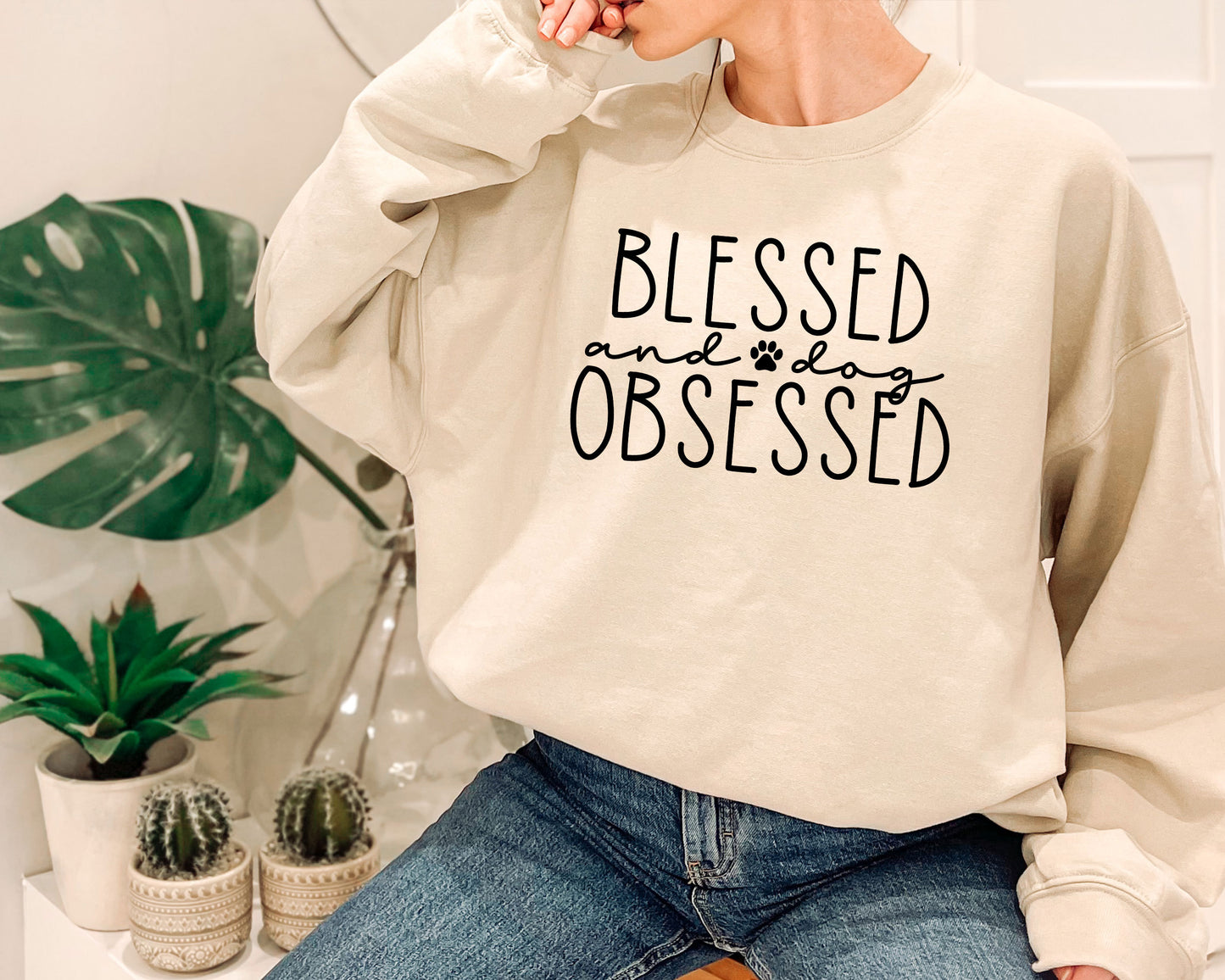 a woman sitting on a stool wearing a sweatshirt