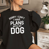 a woman sitting on a bed wearing a black sweatshirt that says sorry i can '